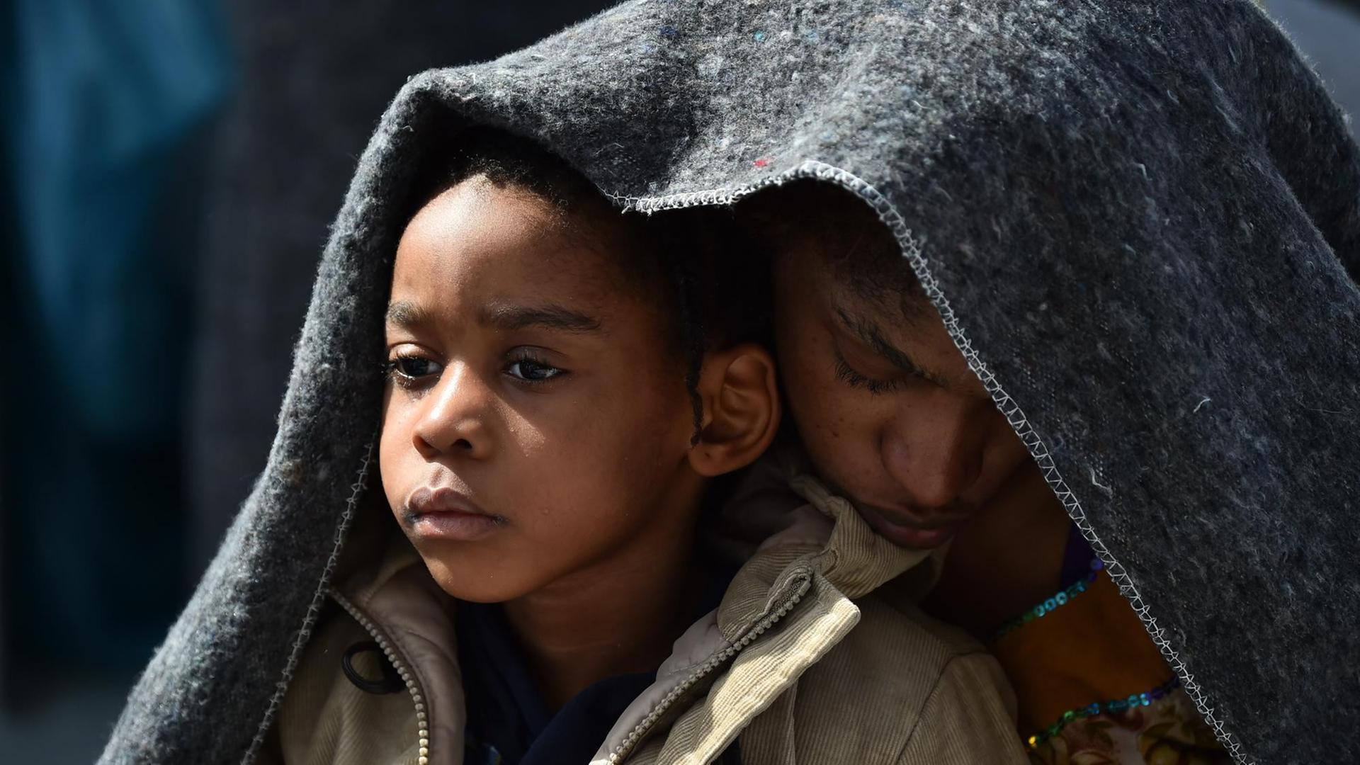 Eine Frau und ihre Tochter schützen sich unter einer Decke auf dem Flüchtlingsrettungsschiff Aquarius, das sie vor der Küste Libyens aufgegriffen hat. Eine Frau und ihre Tochter schützen sich unter einer Decke auf dem Flüchtlingsrettungsschiff Aquarius, das sie vor der Küste Libyens aufgegriffen hat.