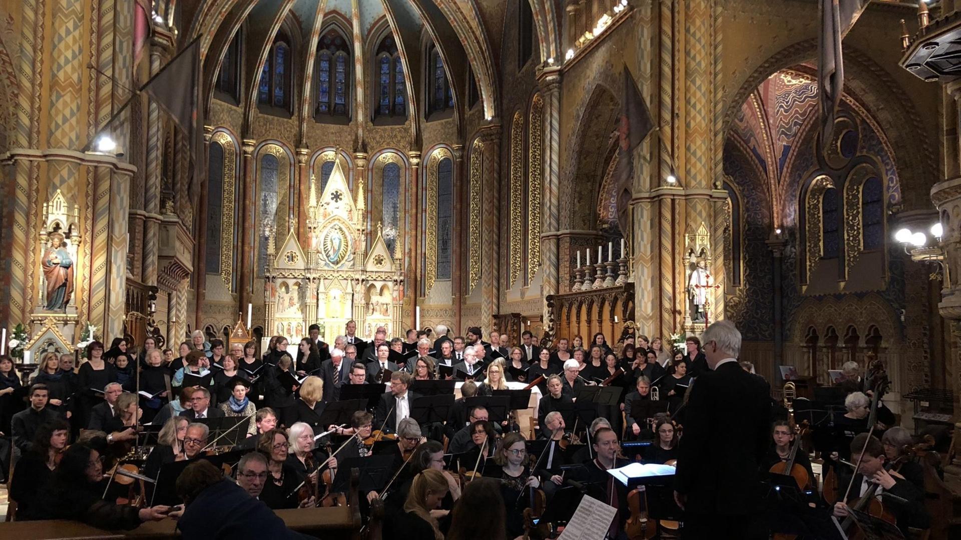 Chor und Orchester vor goldenem Altar in einer Kirche Chor und Orchester vor goldenem Altar in einer Kirche