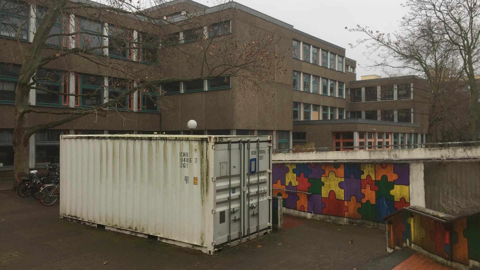 Im Vordergrund steht ein Container, im Hintergrund das Gebäude der Kurt-Schumacher-Grundschule in Berlin-Kreuzberg, das saniert werden soll.