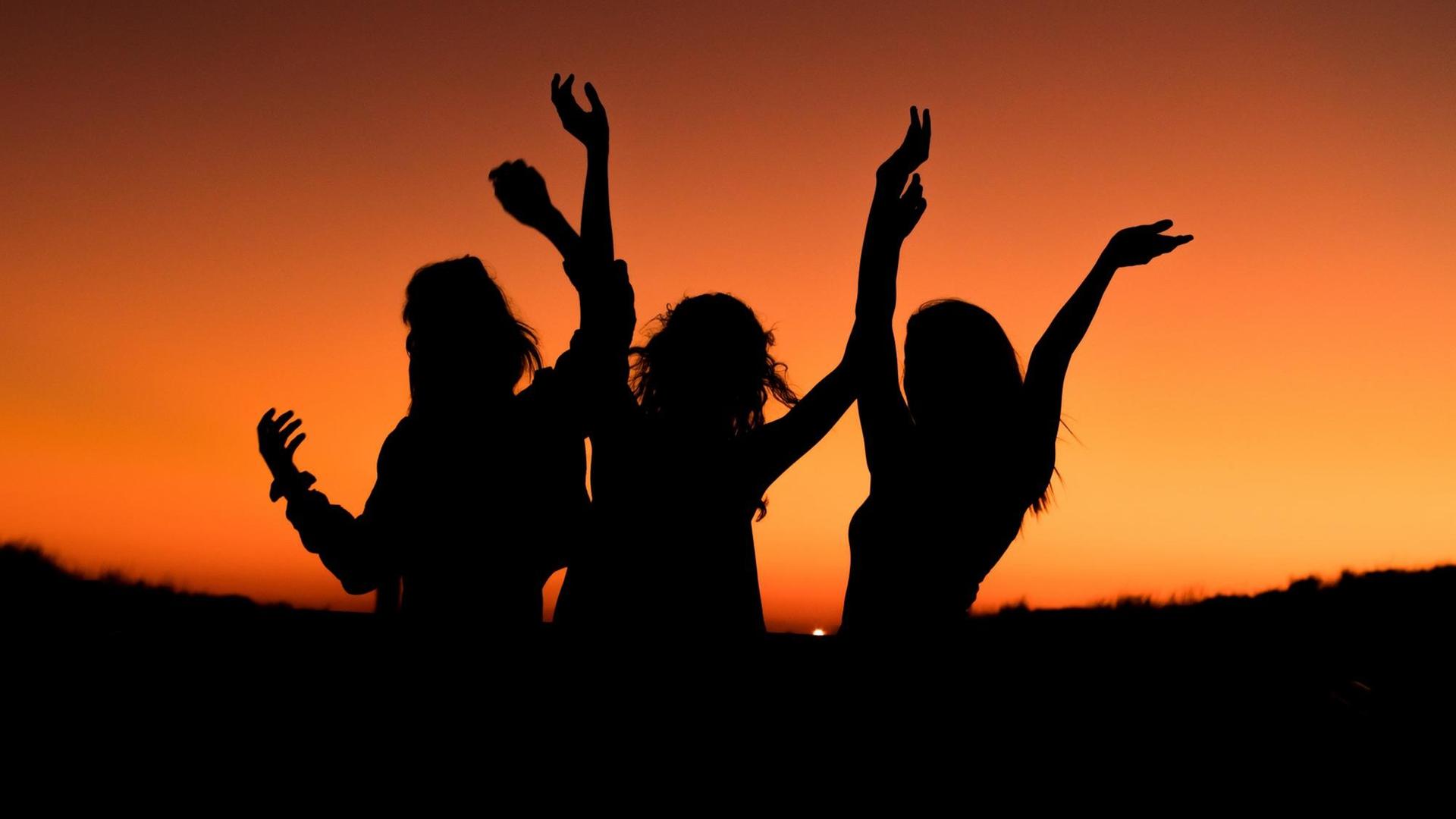 Frauen, die vor dem Sonnenuntergang tanzen.