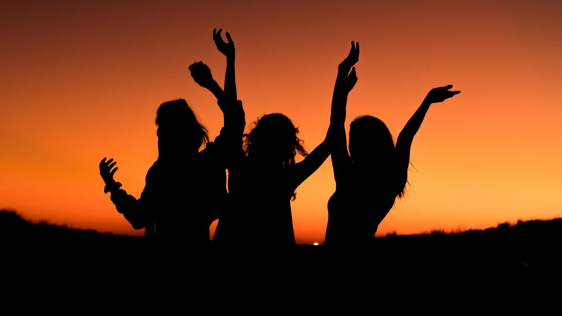 Frauen, die vor dem Sonnenuntergang tanzen. Frauen, die vor dem Sonnenuntergang tanzen.
