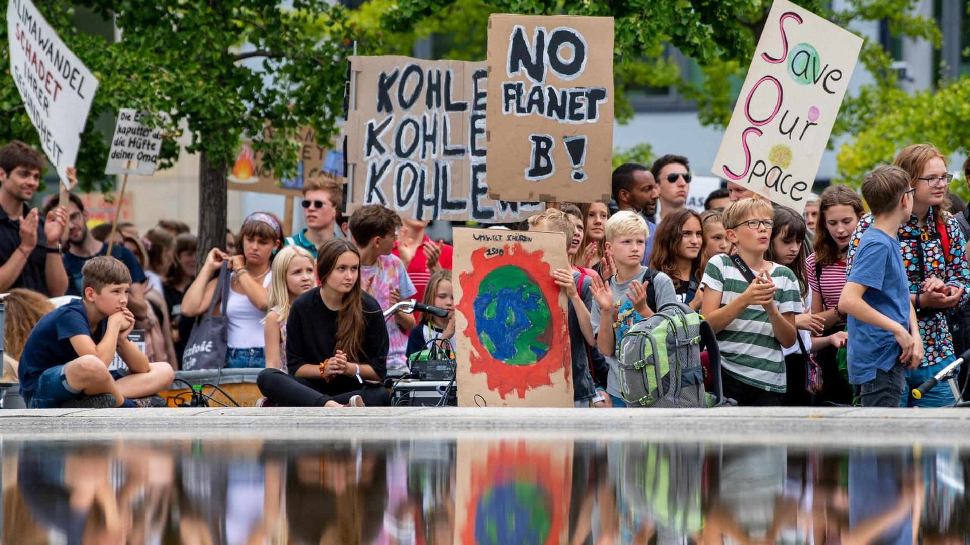 Teilnehmer der Klimademonstration "Fridays for Future" stehen mit ihren Transparenten im Invalidenpark. Teilnehmer der Klimademonstration "Fridays for Future" stehen mit ihren Transparenten im Invalidenpark.