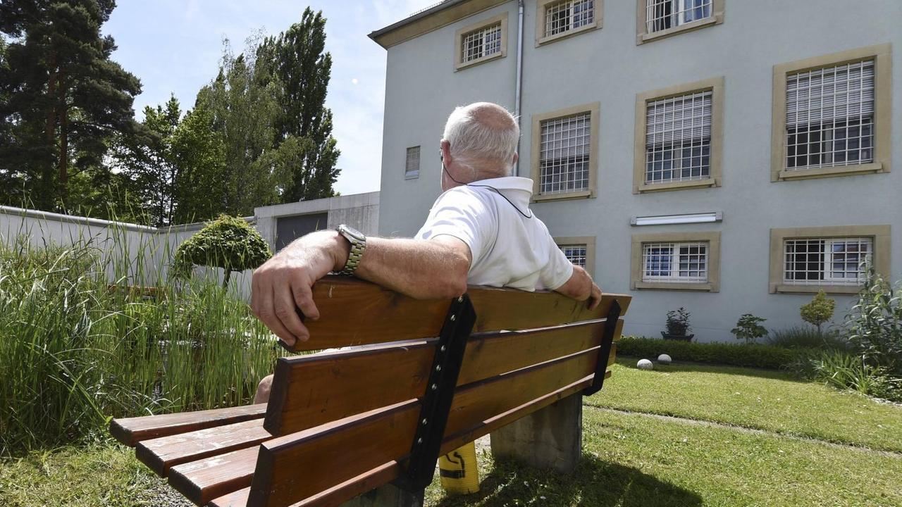 Ein älterer Häftling sitzt vor dem Gefängnisgebäude in Singen (Baden-Württemberg) Ein älterer Häftling sitzt vor dem Gefängnisgebäude in Singen (Baden-Württemberg)