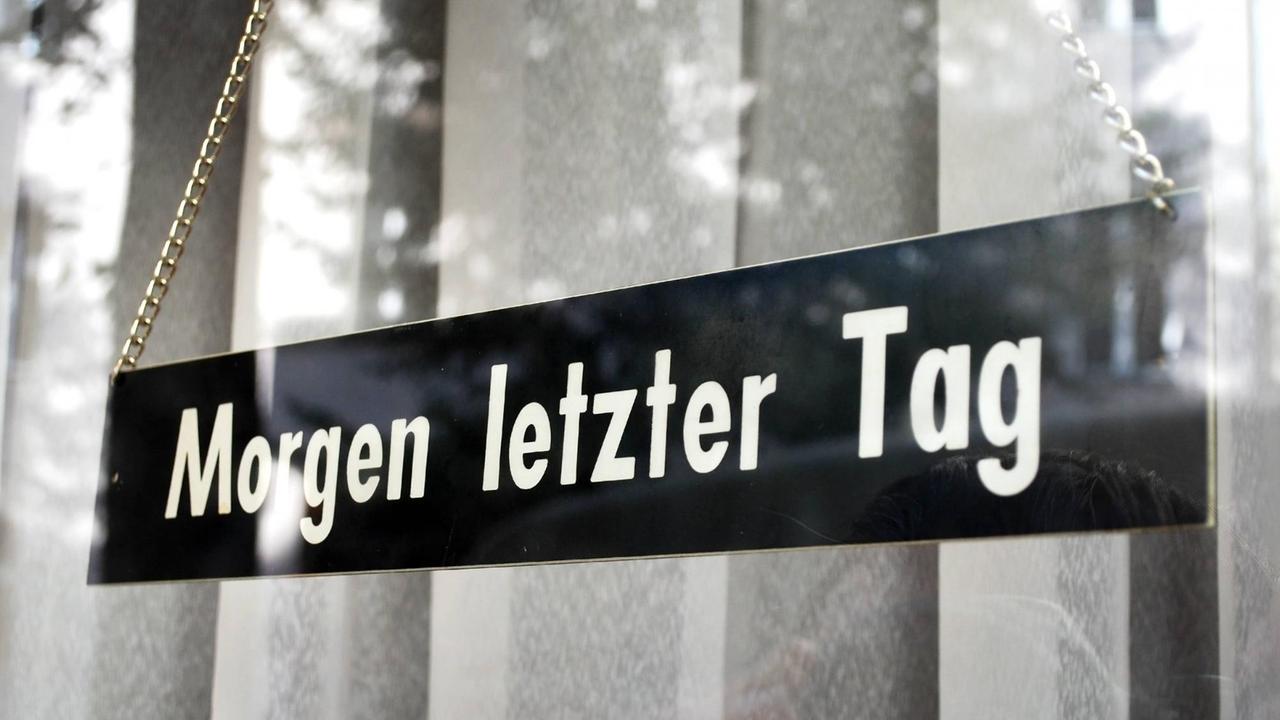 "Morgen letzer Tag" verkündet ein Schild, welches vor einem dicken Vorhang hängt. "Morgen letzer Tag" verkündet ein Schild, welches vor einem dicken Vorhang hängt.
