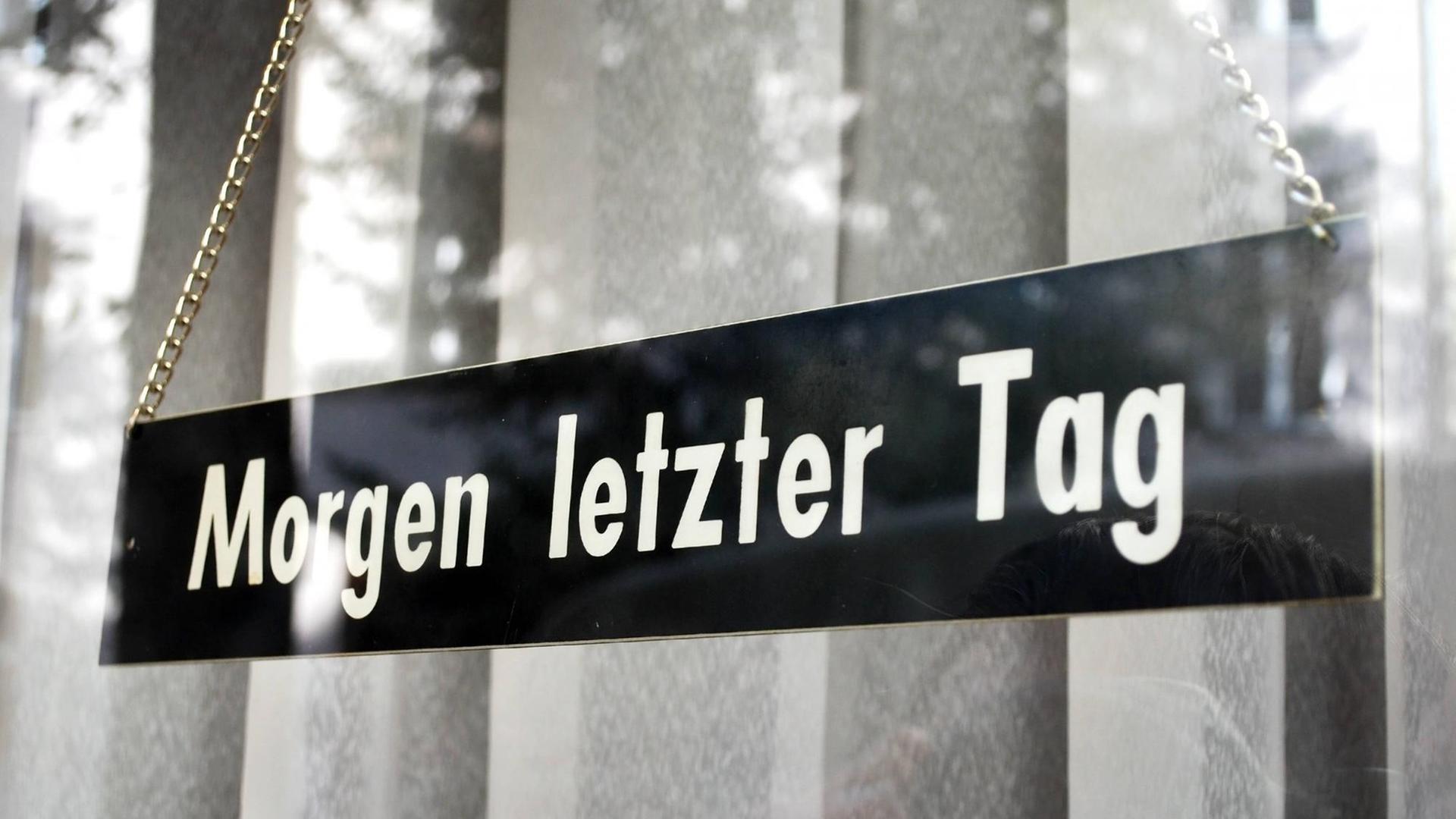 "Morgen letzer Tag" verkündet ein Schild, welches vor einem dicken Vorhang hängt. "Morgen letzer Tag" verkündet ein Schild, welches vor einem dicken Vorhang hängt.