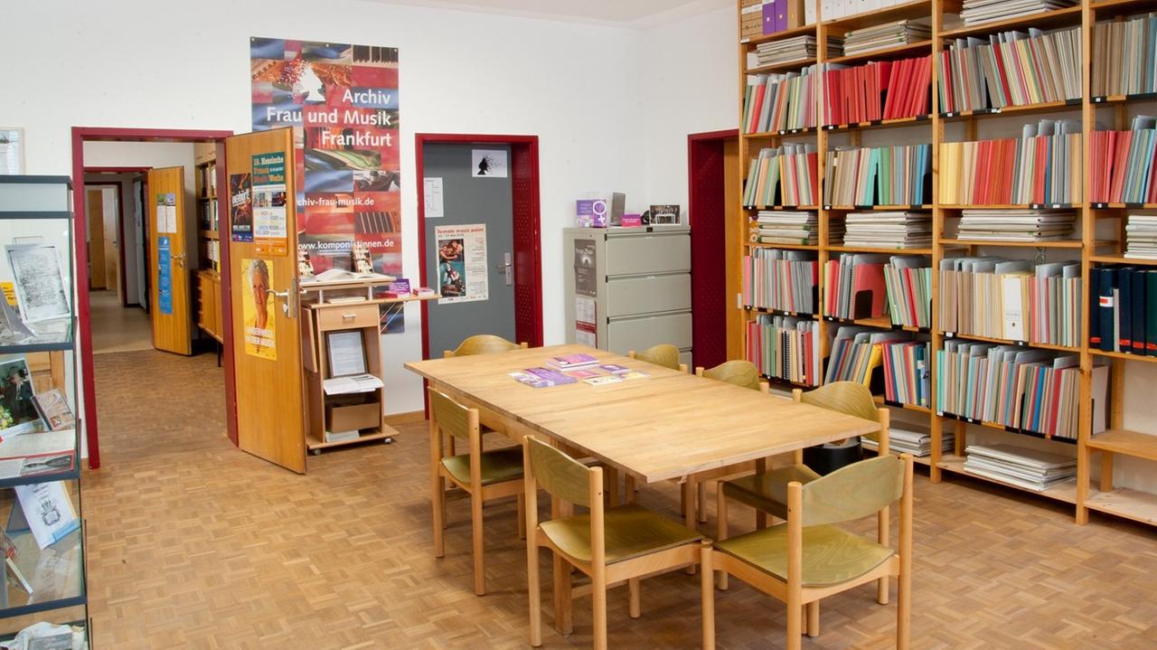 Ein Archivraum mit Lesetisch und Regalen, eine offene Tür führt auf den Flur. Ein Archivraum mit Lesetisch und Regalen, eine offene Tür führt auf den Flur.