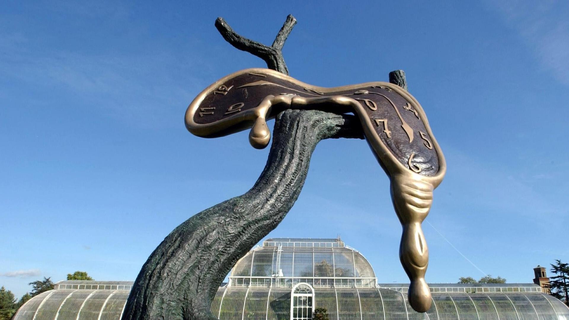 Das Foto zeigt ein Exemplar der Bronzeskulptur "Profil der Zeit" von Salvador Dalí. Eine schmelzend dargestellte Uhr scheint dabei von den Ästen eines Baumes zu laufen.