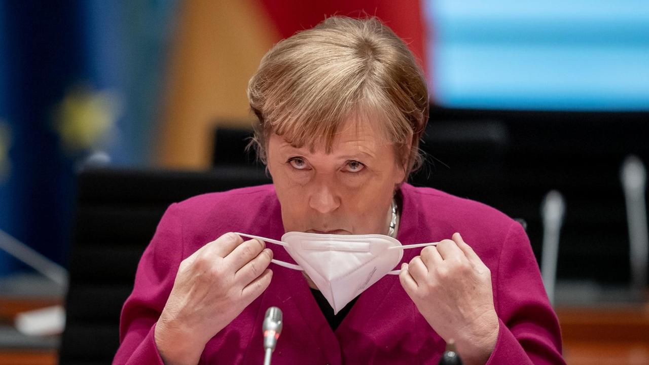 Bundeskanzlerin Angela Merkel nimmt zu Beginn der Sitzung des Bundeskabinetts im Kanzleramt ihre Maske ab Bundeskanzlerin Angela Merkel nimmt zu Beginn der Sitzung des Bundeskabinetts im Kanzleramt ihre Maske ab