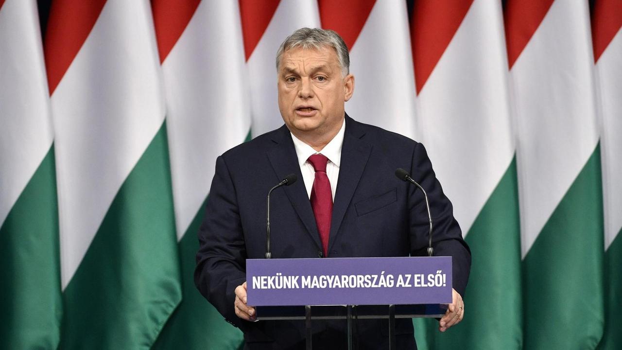 Viktor Orban, Ministerpräsident von Ungarn, steht an einem Rednerpult. Im Hintergrund mehrere ungarische Flaggen. Viktor Orban, Ministerpräsident von Ungarn, steht an einem Rednerpult. Im Hintergrund mehrere ungarische Flaggen.
