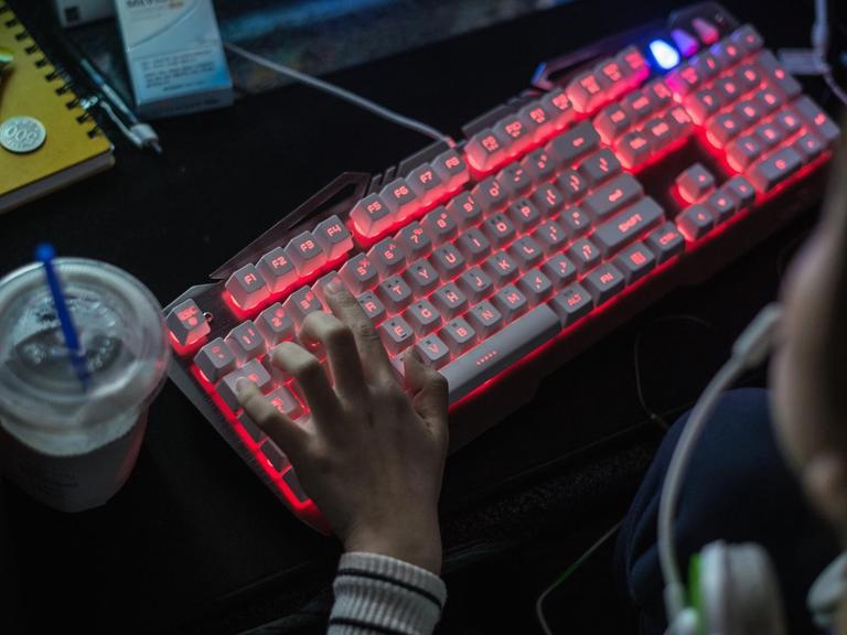 Eine Frau schreibt auf der Tastatur eines Computers.
