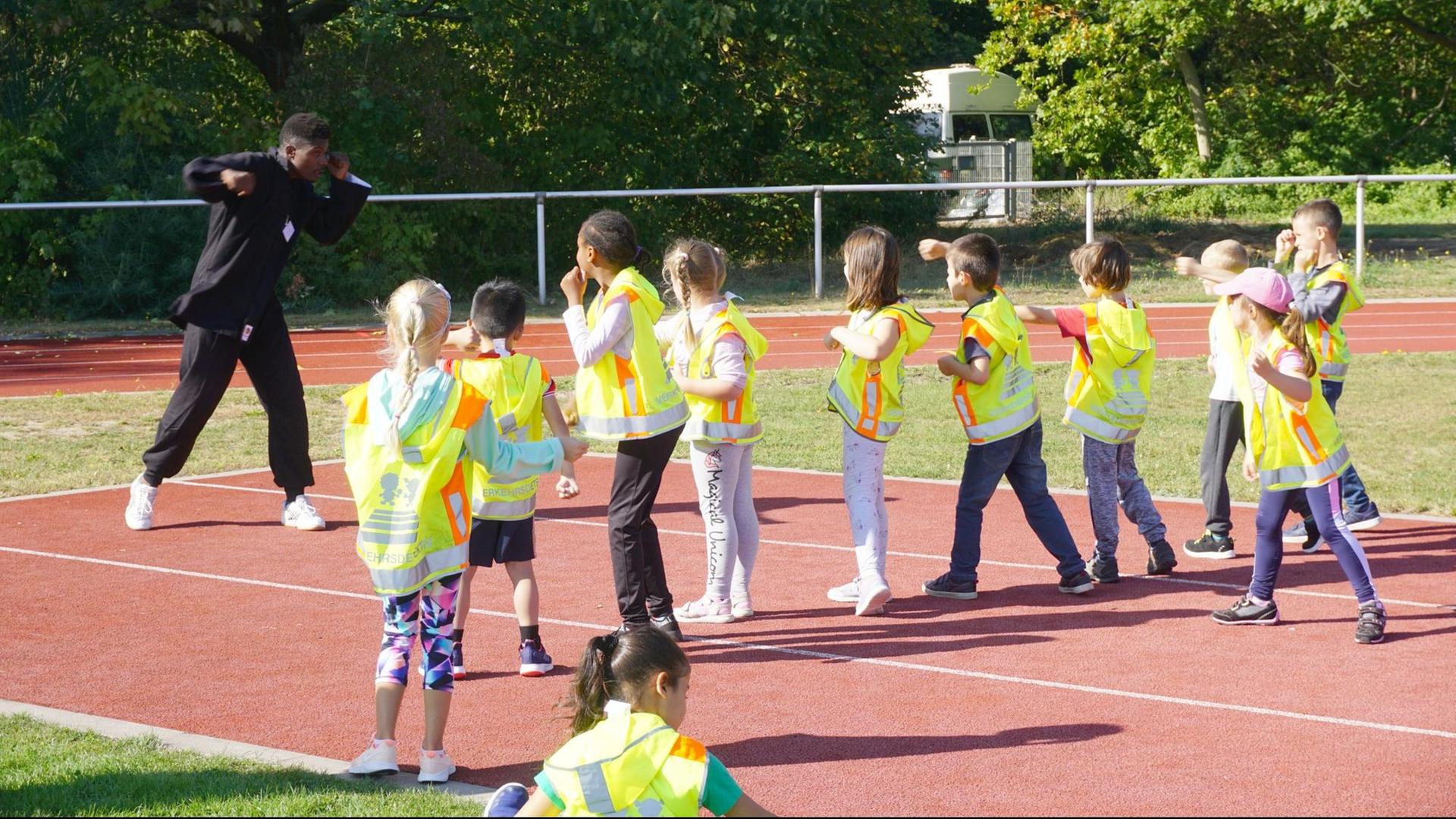 Kinder trainieren auf dem Sportfeld.
