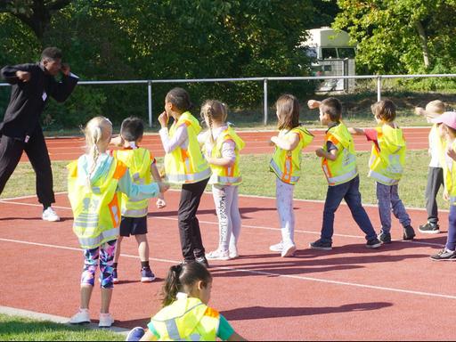 Kinder trainieren auf dem Sportfeld.
