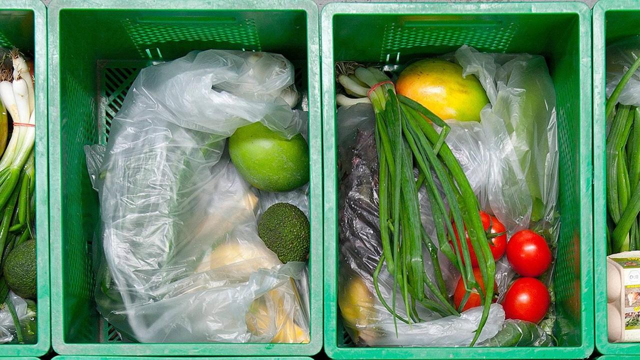 Tüten mit Obst, Gemüse und Eierkartons in grünen Plastikkisten. Tüten mit Obst, Gemüse und Eierkartons in grünen Plastikkisten.