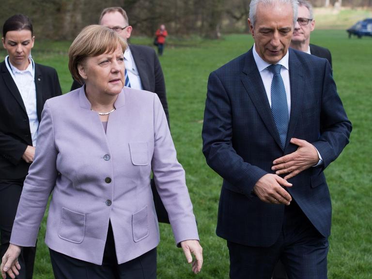 Der Ministerpräsident von Sachsen, Stanislaw Tillich (3.v.r. - CDU) und Bundeskanzlerin Angela Merkel (CDU) laufen am 06.04.2017 durch den Fürst Pücklerpark zum Neuen Schloss in Bad Muskau (Sachsen) zur 44. Regionalkonferenz der Ost-Ministerpräsidenten.