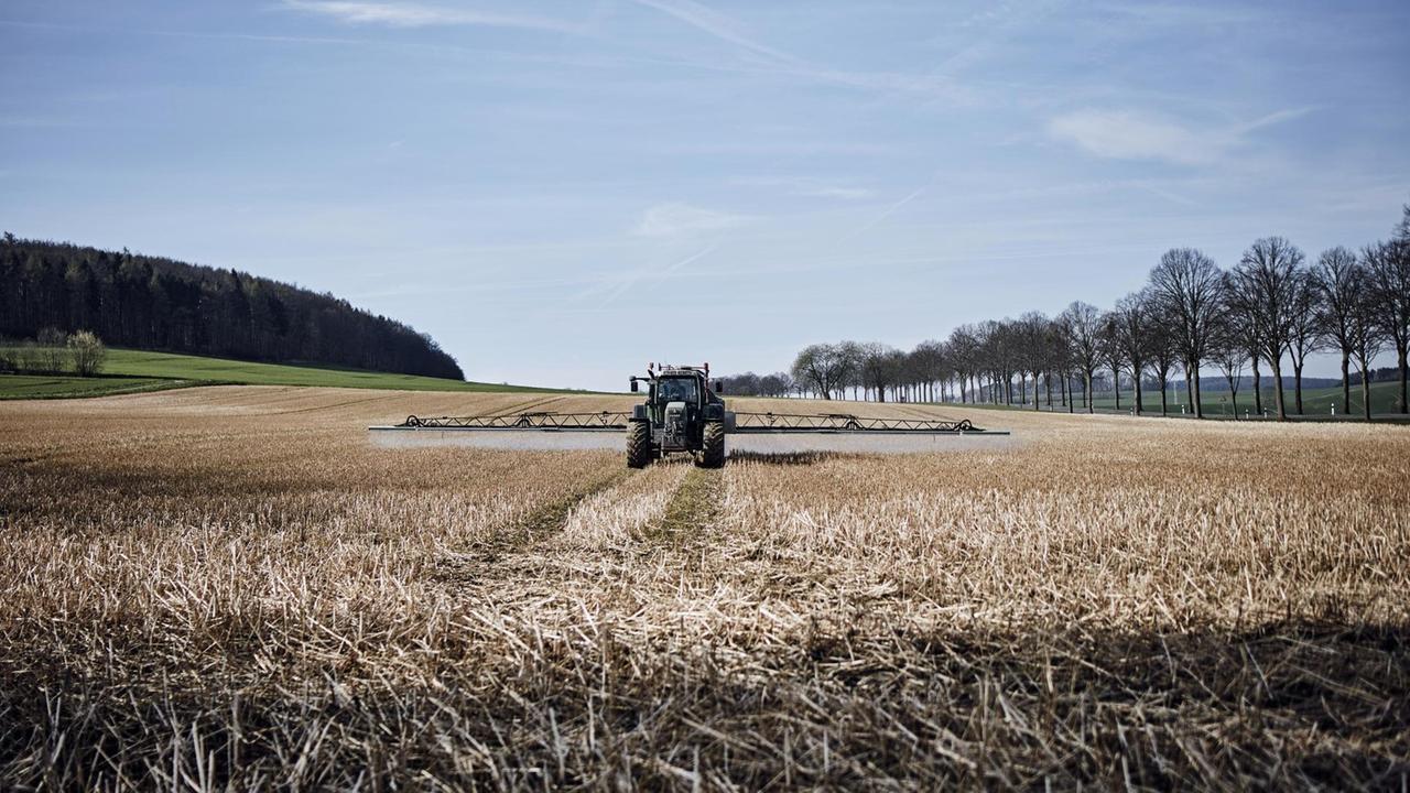 Ein Traktor bringt Glyphosat auf einem Feld in Niedersachsen aus Ein Traktor bringt Glyphosat auf einem Feld in Niedersachsen aus