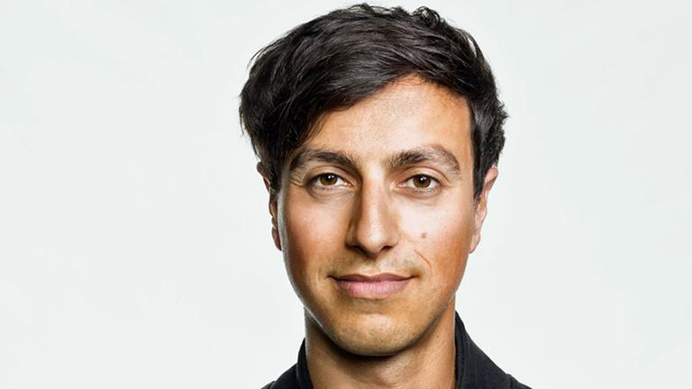 Porträt des deutsch-iranischen Rechtsanwalts und Autors Bijan Moini: ein junger Mann mit dunklen Haaren und Augen lächelt in die Kamera. Porträt des deutsch-iranischen Rechtsanwalts und Autors Bijan Moini: ein junger Mann mit dunklen Haaren und Augen lächelt in die Kamera.