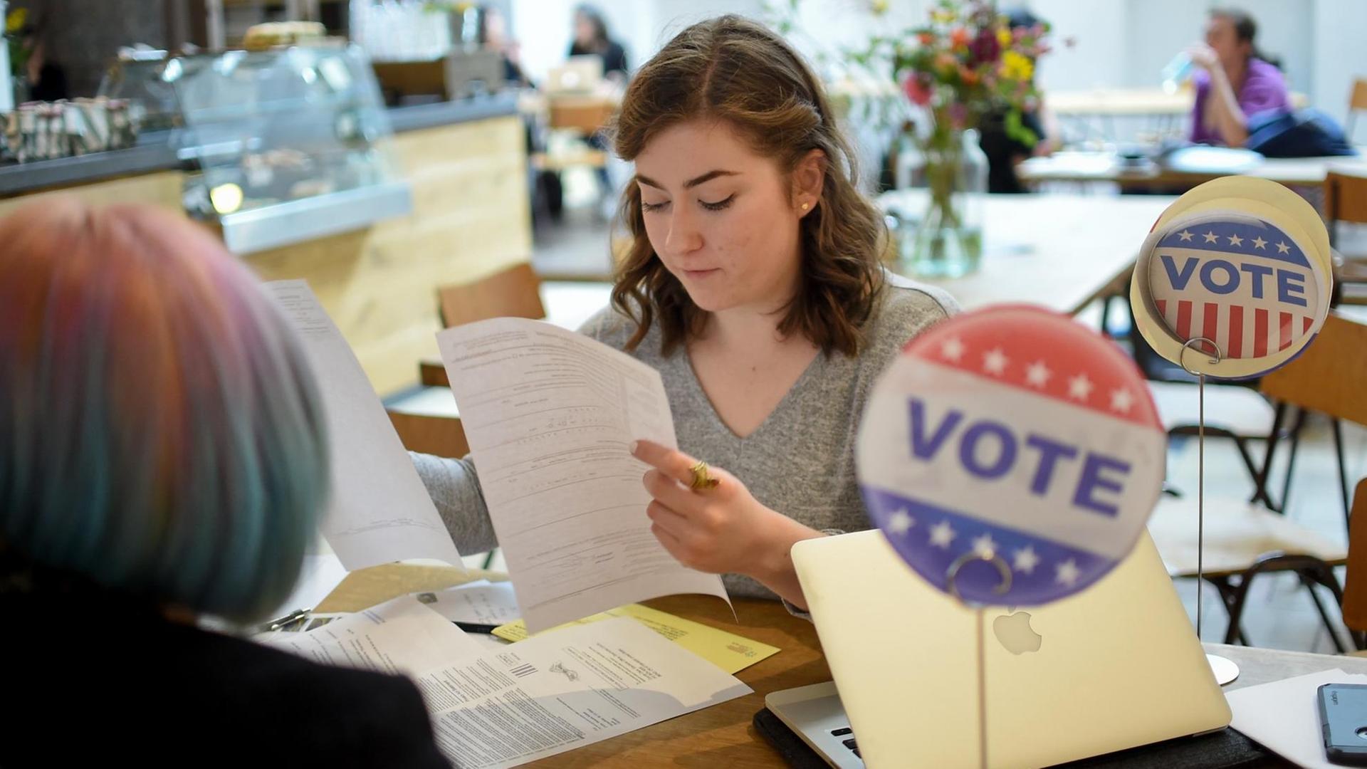 In Berlin unterstützt eine junge Frau Amerikaner, sich für die US-Wahlen zu registrieren. In Berlin unterstützt eine junge Frau Amerikaner, sich für die US-Wahlen zu registrieren.