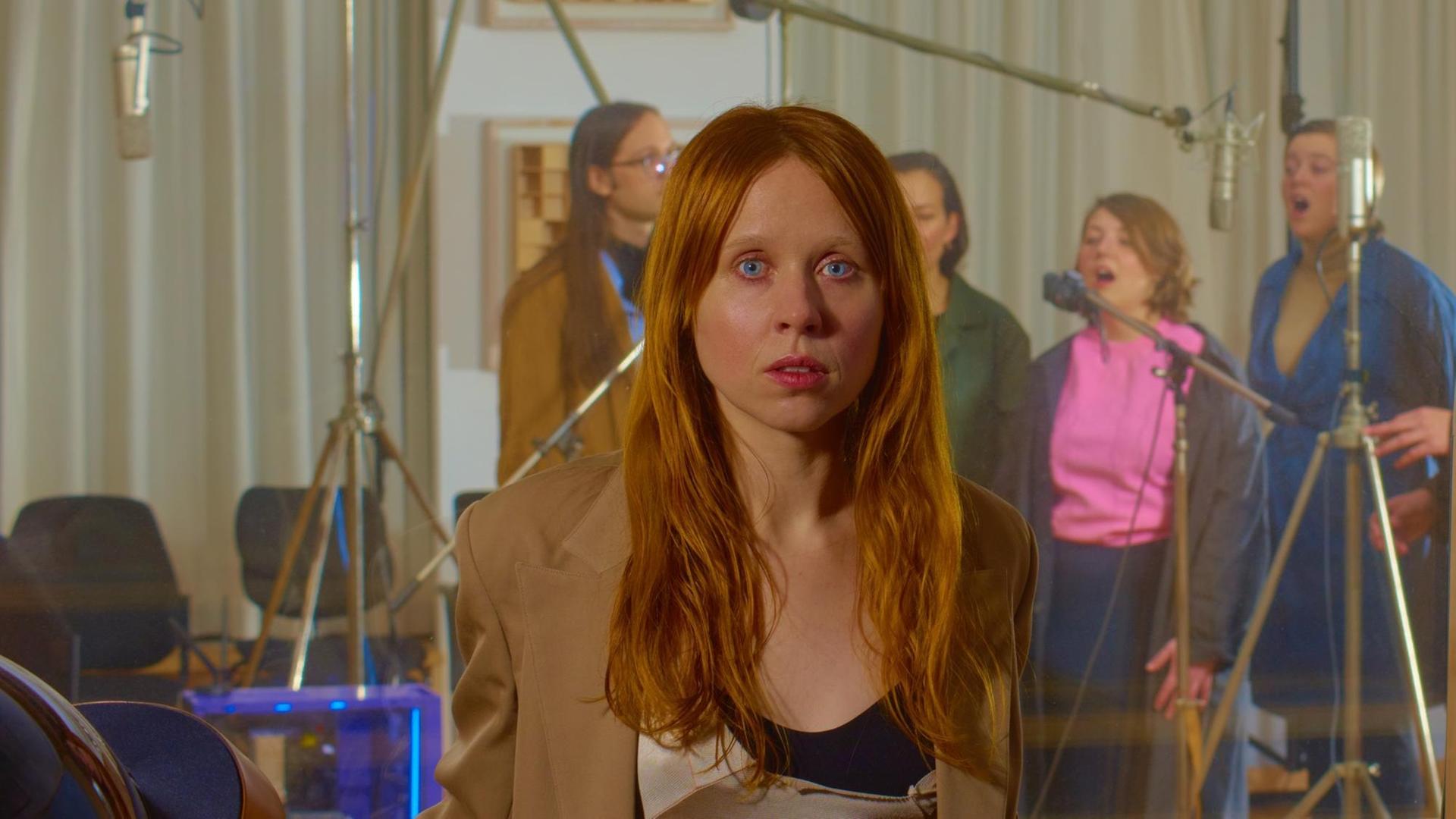Auf dem Bild ist die Komponistin Holly Herndon mit ihrem Proto-Chor zu sehen. Auf dem Bild ist die Komponistin Holly Herndon mit ihrem Proto-Chor zu sehen.