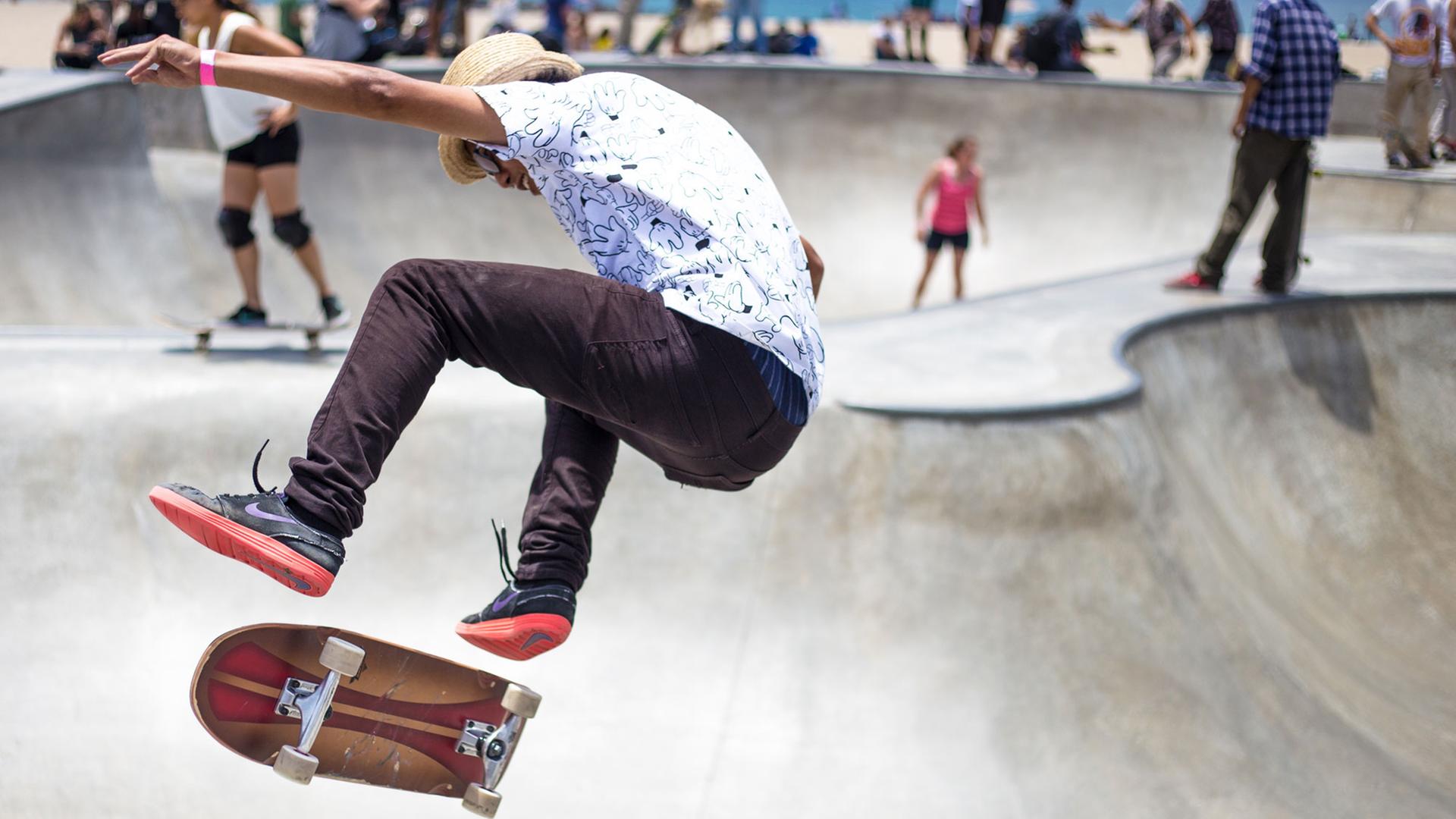 Ein Skater fliegt auf einer Skate-Anlage in die Luft. Ein Skater fliegt auf einer Skate-Anlage in die Luft.