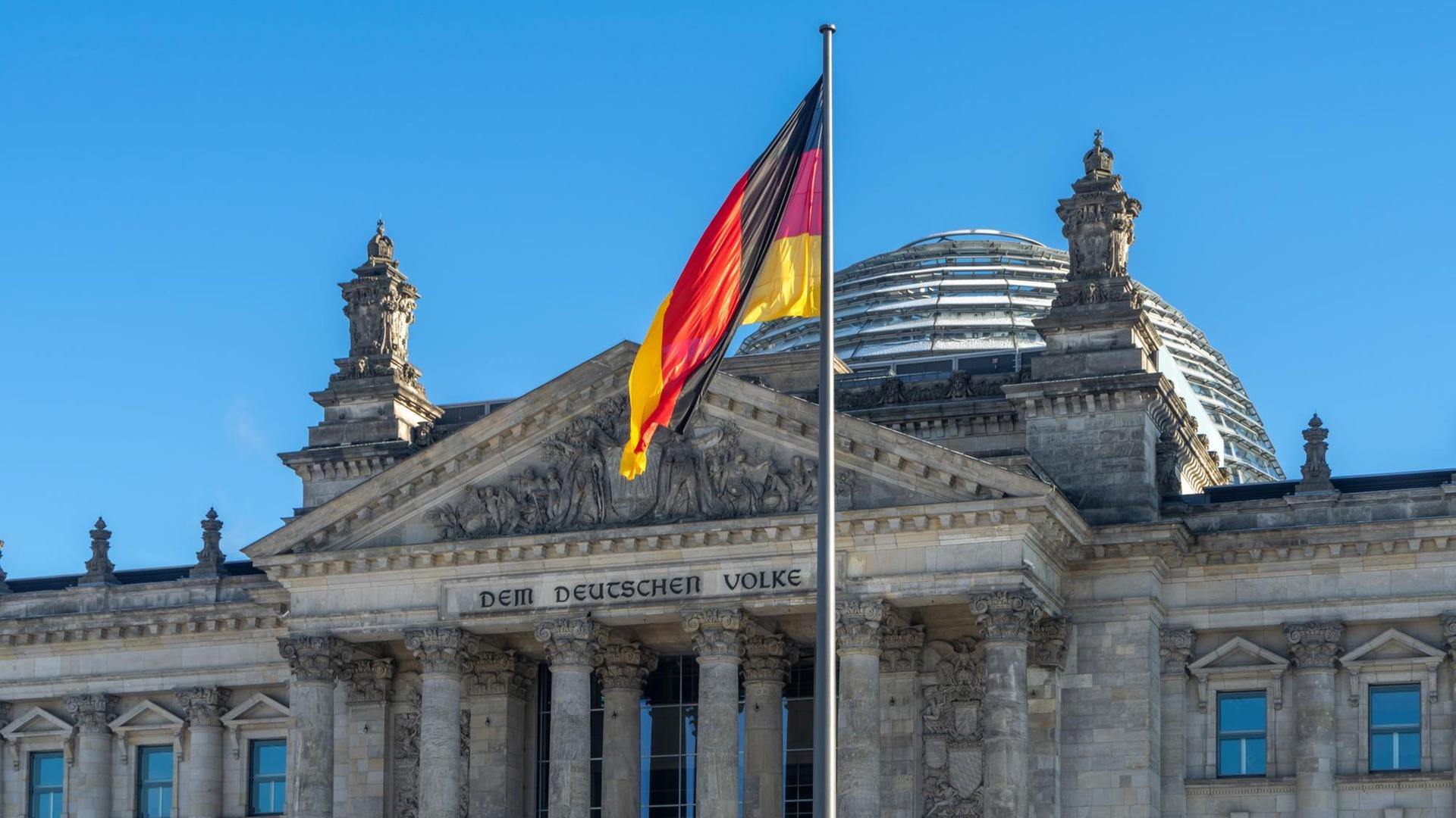 Die deutsche Flagge vor dem Reichstagsgebäude in Berlin.