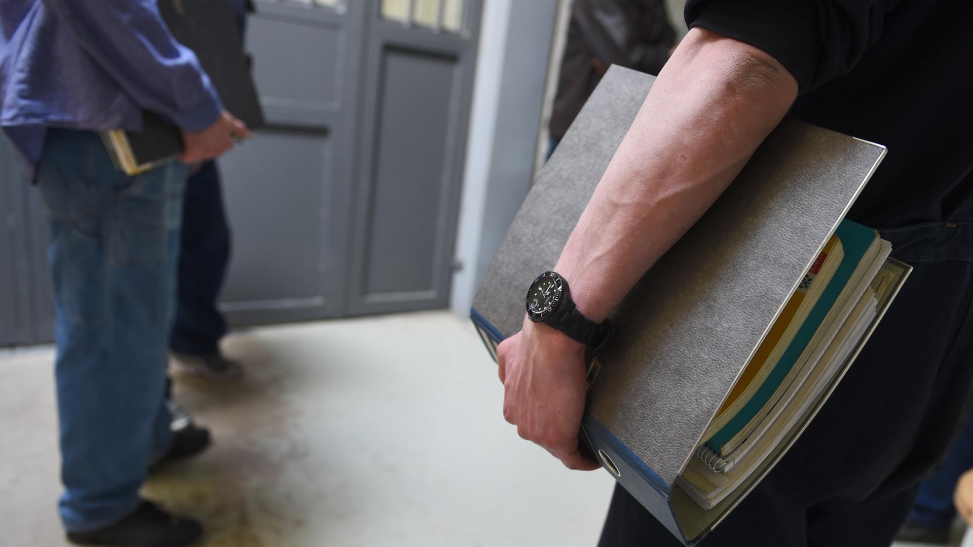 Mehrere Häftlinge der Justizvollzugsanstalt (JVA) Ravensburg stehen am 18.03.2014 an der geschlossenen Eingangstür zum Schultrakt. Mehrere Häftlinge der Justizvollzugsanstalt (JVA) Ravensburg stehen am 18.03.2014 an der geschlossenen Eingangstür zum Schultrakt.