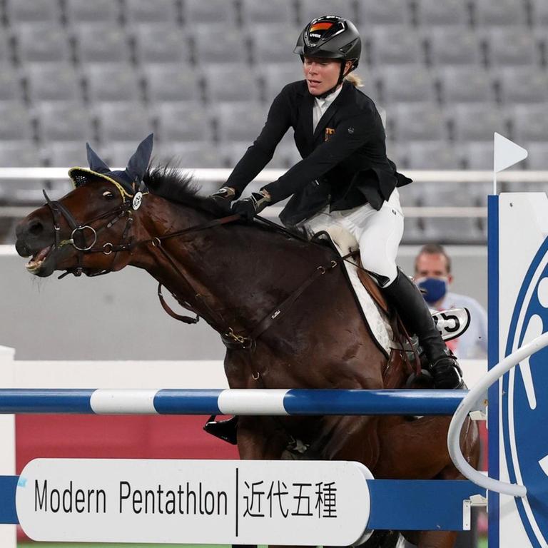 Das Bild zeigt die Reiterin Annika Schleu. Sie sitzt auf einem Pferd. Das Pferd will nicht über ein Hindernis springen. Das war bei den Olmpischen Spielen.   