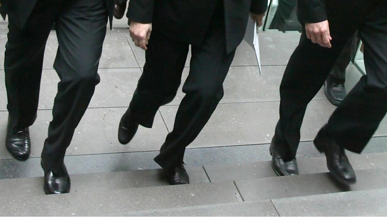 Archivbild: Blick auf die Beine von Edmund Stoiber, Angela Merkel und Guido Westerwelle, die alle in schwarzen Hosen stecken und im Gleichschritt eine Treppe hochgehen. Archivbild: Blick auf die Beine von Edmund Stoiber, Angela Merkel und Guido Westerwelle, die alle in schwarzen Hosen stecken und im Gleichschritt eine Treppe hochgehen.