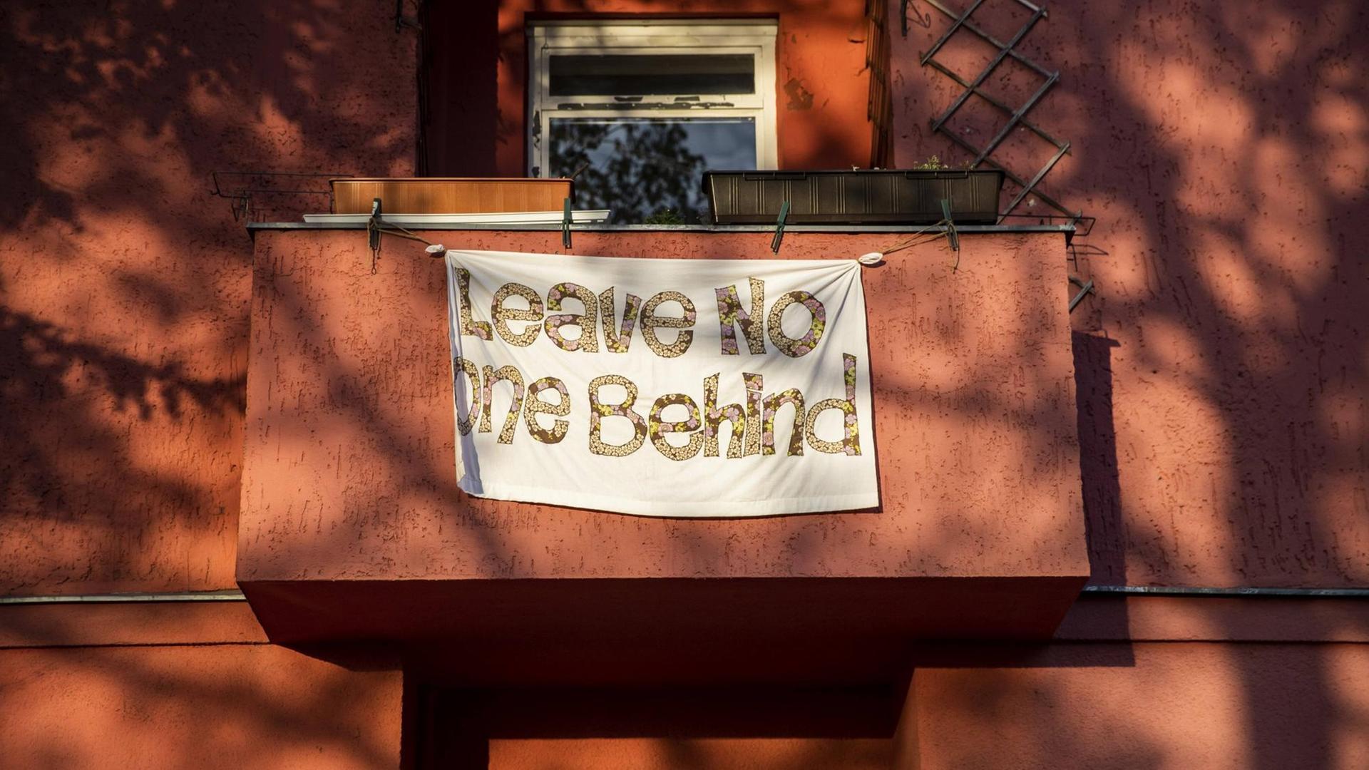 Ein Banner mit dem Schriftzug "Leave Noone Behind" hängt am 17. April 2020 in Berlin an einem Balkon.