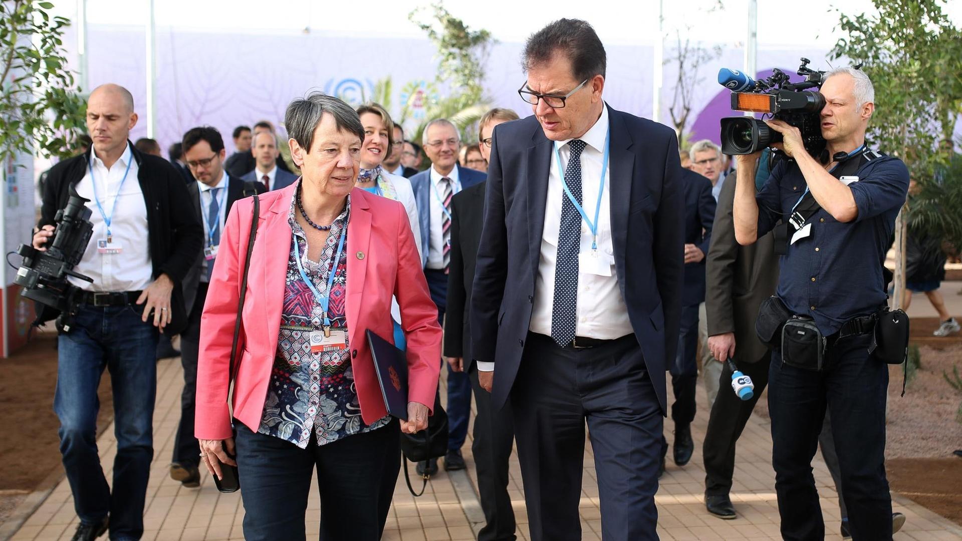 Barbara Hendricks und Gerd Müller gehen begleitet von einem Tross von Menschen auf die Kamera zu Barbara Hendricks und Gerd Müller gehen begleitet von einem Tross von Menschen auf die Kamera zu