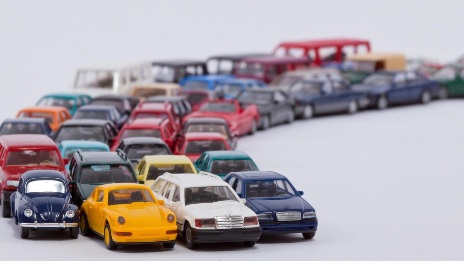 Eine lange Schlange von Spielzeugautos wartet auf die Weiterfahrt Eine lange Schlange von Spielzeugautos wartet auf die Weiterfahrt