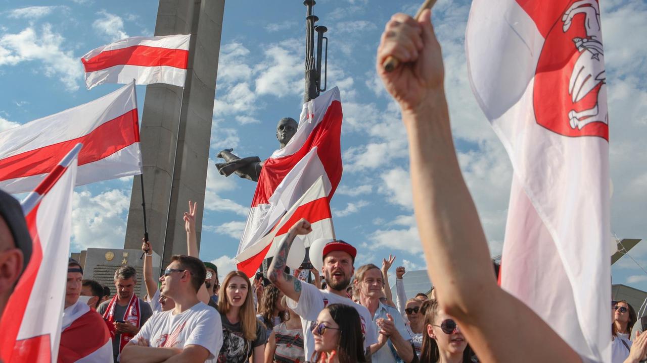 Demonstranten strecken die rot-weißen Flaggen gen Himmel. Demonstranten strecken die rot-weißen Flaggen gen Himmel.