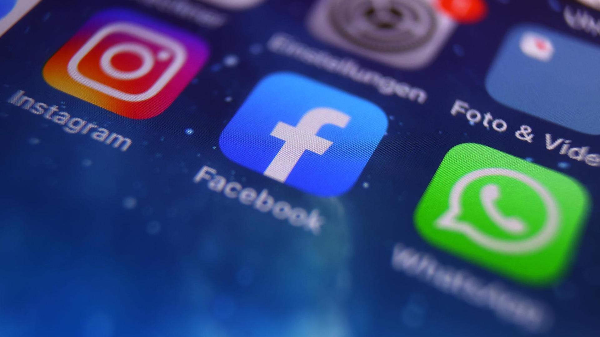 Auf dem Bildschirm eines Smartphones sind die Icons von Instagram, Facebook und WhatsApp zu sehen.