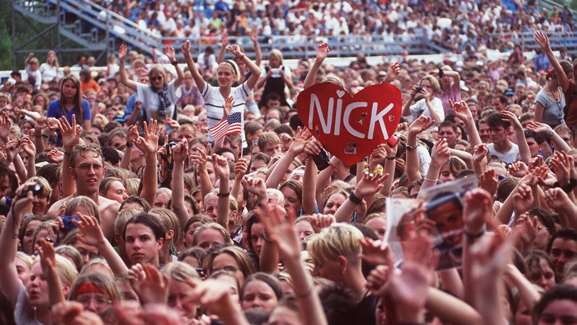 Jugendliche Fans bei einem Popkonzert der Backstreet Boys am 01.09.1996. Ein Plakat in Herzform wird hochgehalten, auf dem "Nick" steht, der Name eines der Bandmitglieder