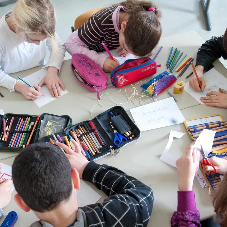 Schüler einer 5. Klasse der BiL-Privatschule in Stuttgart sitzen an einem Tisch und malen