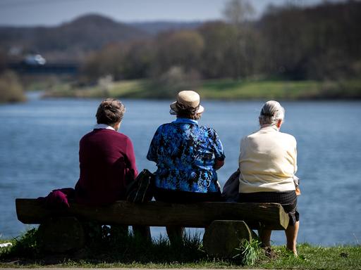 Drei Frauen sitzen am Kemnader See in Bochum in der Sonne.