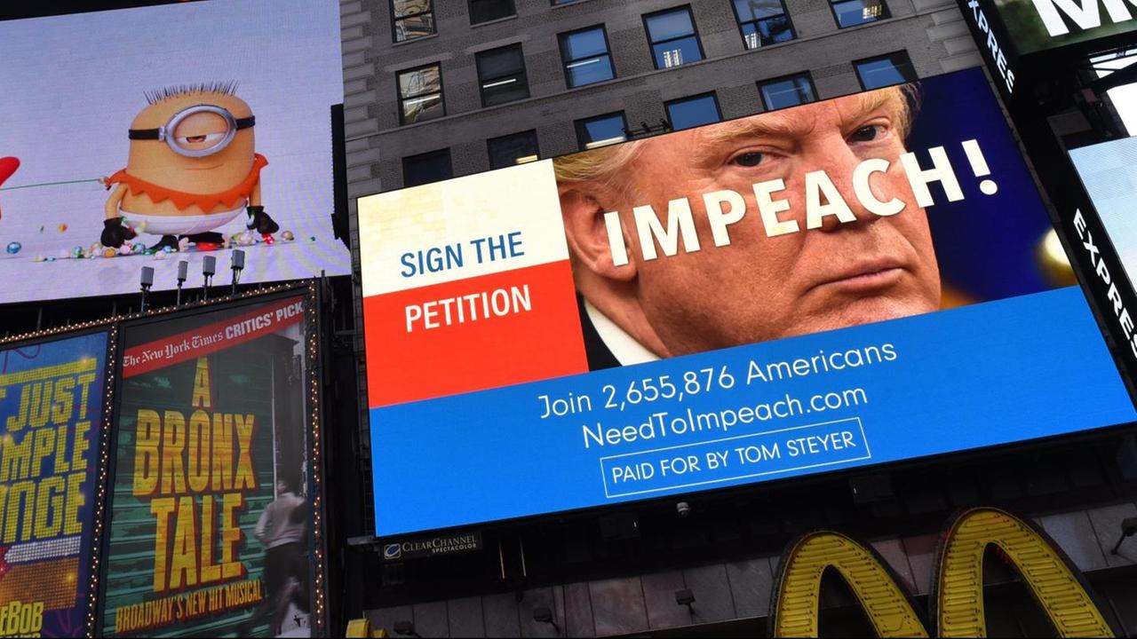 Auf der Werbetafel prangt ein Bild von Trump. Über das Gesicht ist das Wort "Impeach!" geschrieben. Links daneben steht: "Unterschreibe die Petition" Auf der Werbetafel prangt ein Bild von Trump. Über das Gesicht ist das Wort "Impeach!" geschrieben. Links daneben steht: "Unterschreibe die Petition"