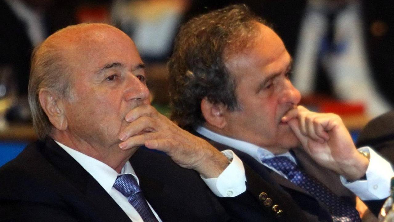 FIFA-Präsident Sepp Blatter und UEFA-Präsident Michel Platini, nebeneinander sitzend, beide eine Hand nachdenklich am Mund. FIFA-Präsident Sepp Blatter und UEFA-Präsident Michel Platini, nebeneinander sitzend, beide eine Hand nachdenklich am Mund.