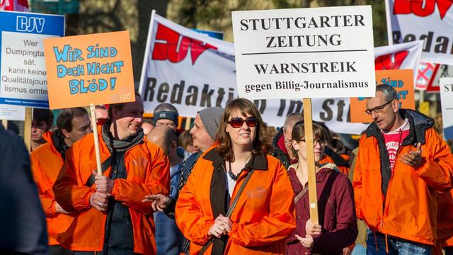Journalisten in München demonstrieren mit Plakaten gegen Sparmaßnahmen.