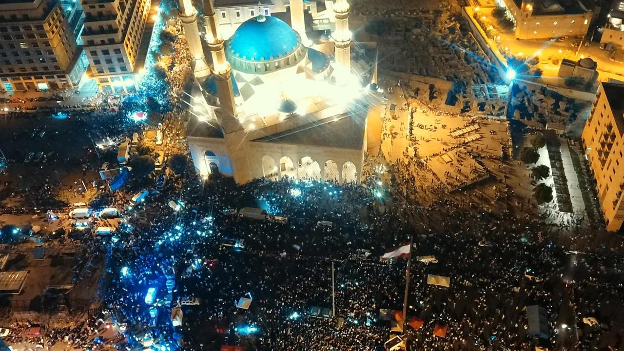 Blick von oben auf Beirut bei Nacht. Tausende Demonstrantinnen und Demonstranten versammeln sich auf zentralen Plätzen. Blick von oben auf Beirut bei Nacht. Tausende Demonstrantinnen und Demonstranten versammeln sich auf zentralen Plätzen.
