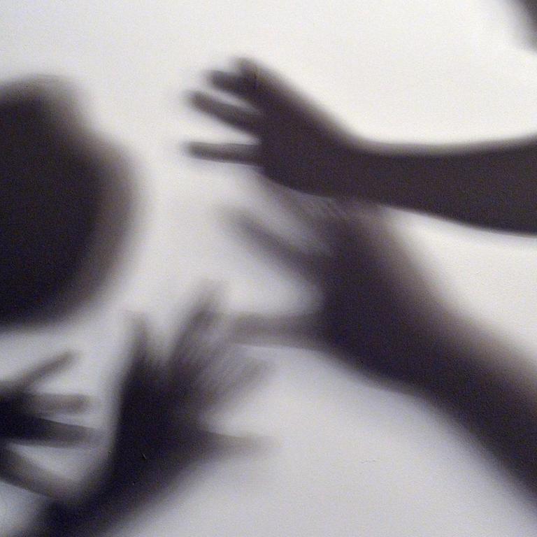 Symbolbild zum Thema häusliche Gewalt: Schatten sollen symbolisieren, wie eine Frau versucht, sich vor der Gewalt eines Mannes zu schützen.
