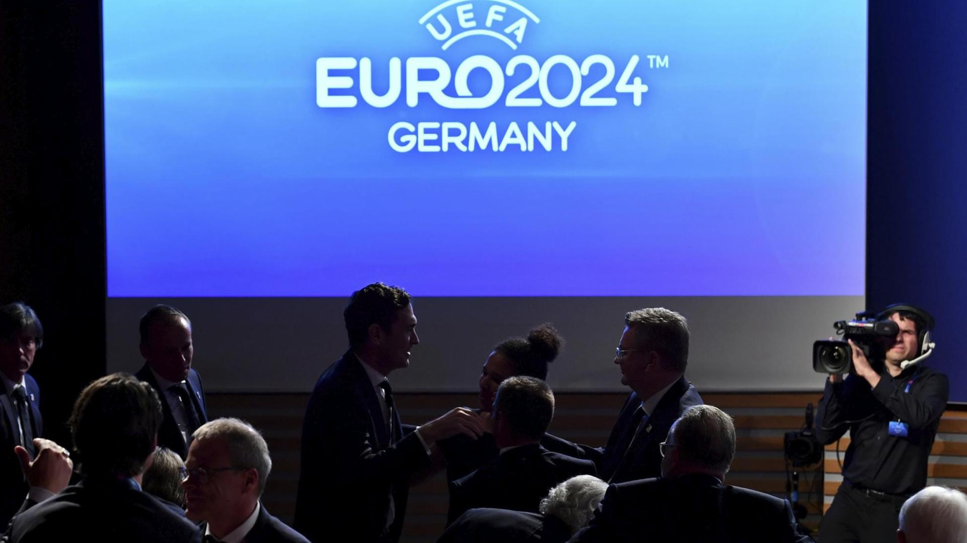 Zu sehen mit weißer Schrift auf blauem Hintergrund: "UEFA - Euro 2024 - Germany". Zu sehen mit weißer Schrift auf blauem Hintergrund: "UEFA - Euro 2024 - Germany".