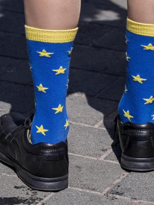 Eine Person trägt hochgezogene Socken im Design der europäischen Flagge.