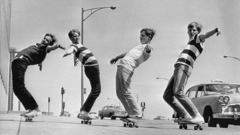 Eine s/w Aufnahme vom Mai 1965 zeigt vier Jungen aus Chicago, die auf ihren Skateboards über den Bürgersteig balancieren.
