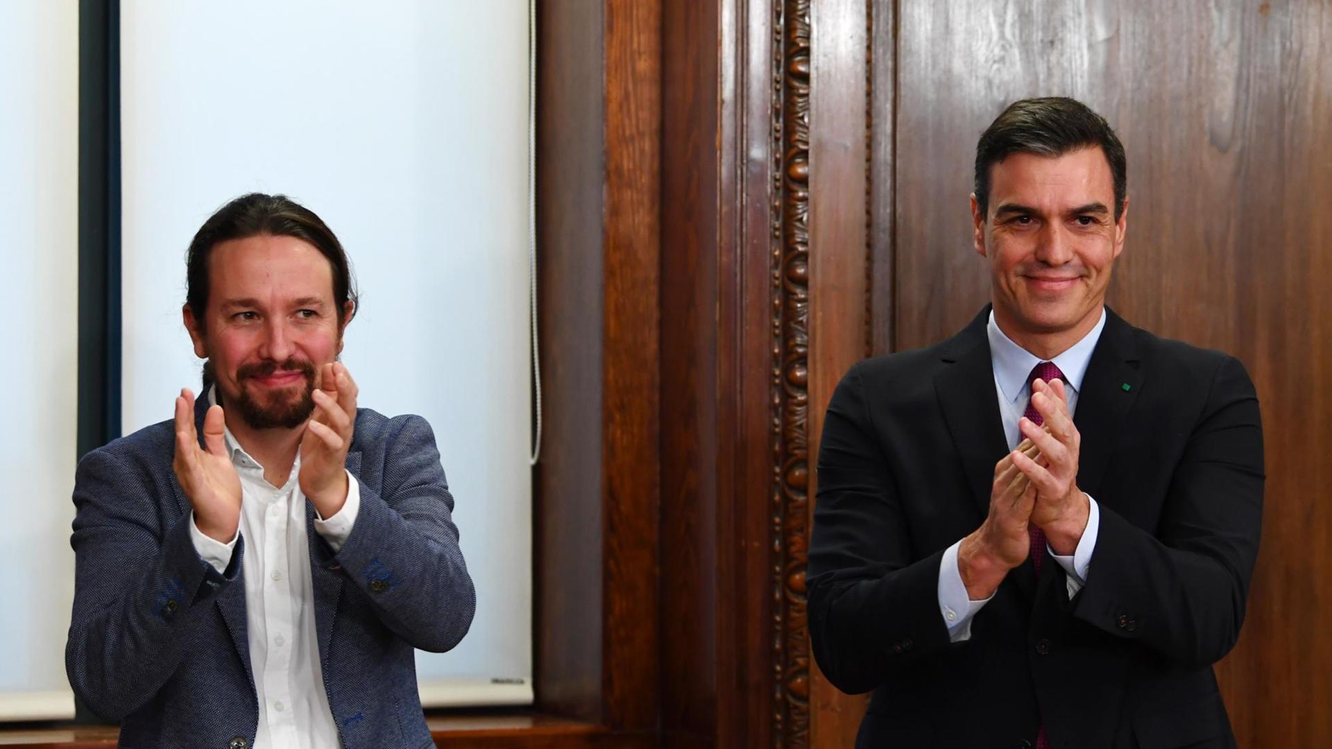 Der Vorsitzende der linken Podemos-Partei, Pablo Iglesias (L) und der spanische Ministerpräsident und Kandidat für die Wiederwahl, der Sozialist Pedro Sanchez, applaudieren nach der Unterzeichnung ihres Regierungsabkommens auf dem Kongress in Madrid am 30. Dezember 2019. Der Vorsitzende der linken Podemos-Partei, Pablo Iglesias (L) und der spanische Ministerpräsident und Kandidat für die Wiederwahl, der Sozialist Pedro Sanchez, applaudieren nach der Unterzeichnung ihres Regierungsabkommens auf dem Kongress in Madrid am 30. Dezember 2019.
