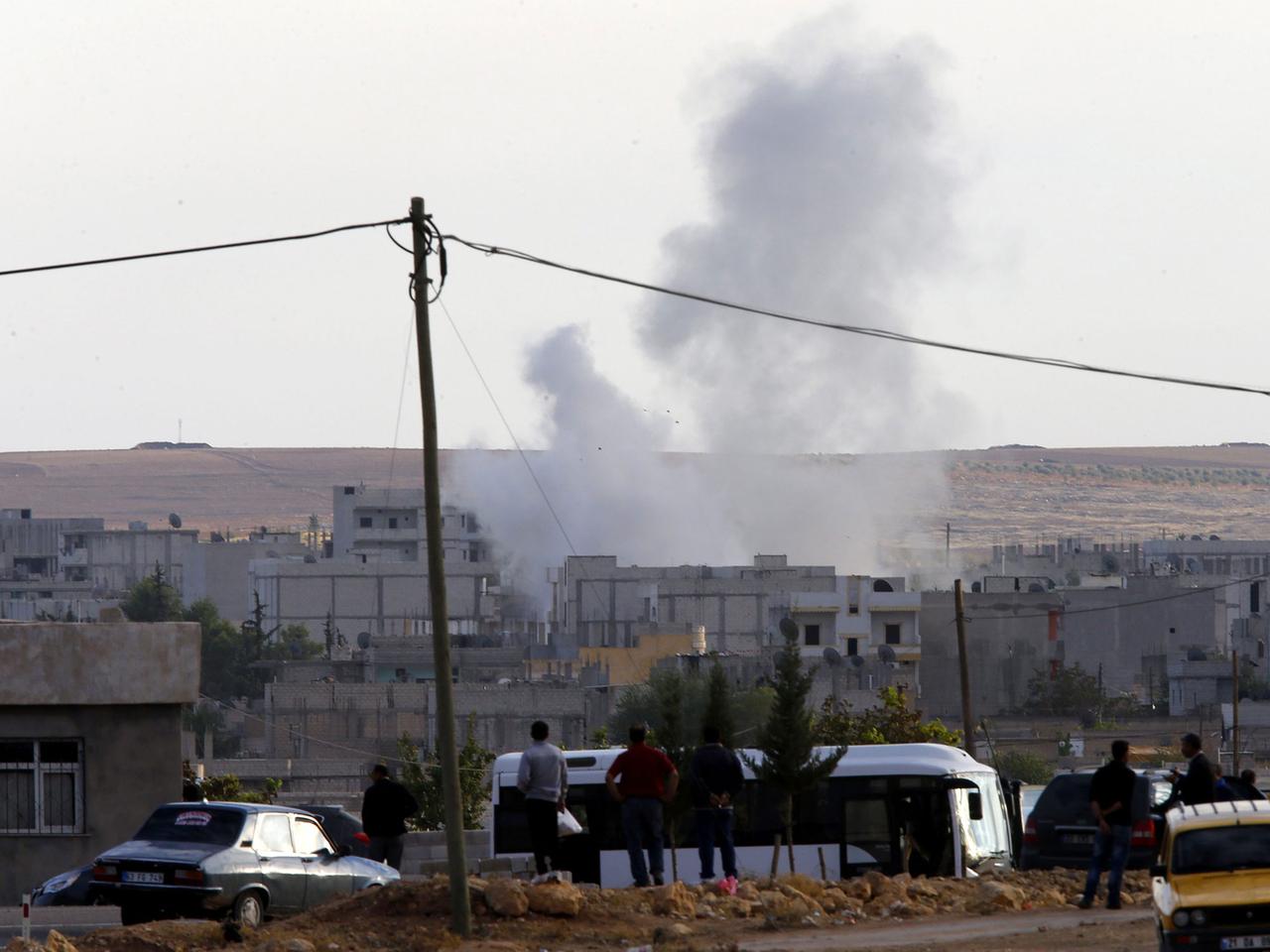 Aus der Nähe der türkischen Stadt Sanliurfa ist zu sehen, wie Rauch über der nordsyrischen Stadt Kobane nach einem offensichtlichen IS-Angriff aufsteigt. Aus der Nähe der türkischen Stadt Sanliurfa ist zu sehen, wie Rauch über der nordsyrischen Stadt Kobane nach einem offensichtlichen IS-Angriff aufsteigt.