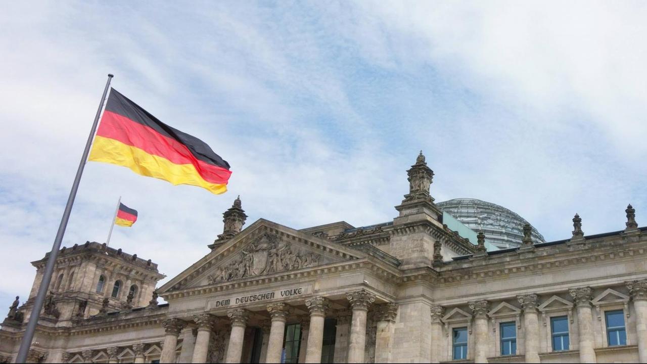 Reichstagsgebäude im Regierungsviertel in Berlin-Mitte am 14.06.2017. Berlin-Mitte: Wehende Flaggen auf dem Reichstagsgebäude, dem Sitz des Deutschen Bundestages.