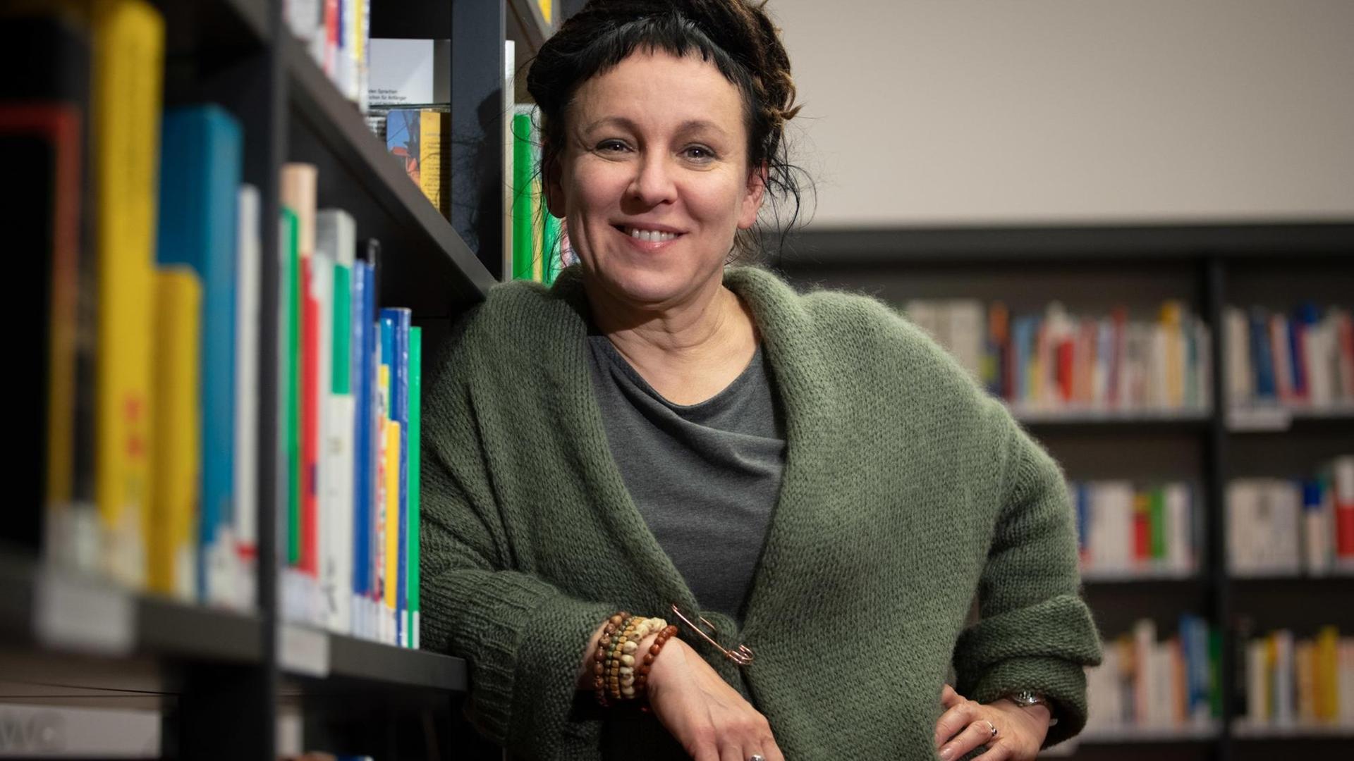 Die polnische Autorin Olga Tokarczuk steht im Vorfeld einer Lesung an einem Bücherregal.