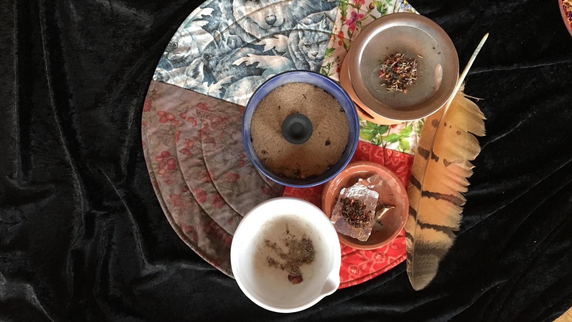 Räucher-Utensilien: weißer Mörser, blaue Räucherschale mit Kohle-Tablette und Quarzsand, Stövchen mit Metallsieb, kleine Schale mit Kräutermischung auf Silberfolie Räucher-Utensilien: weißer Mörser, blaue Räucherschale mit Kohle-Tablette und Quarzsand, Stövchen mit Metallsieb, kleine Schale mit Kräutermischung auf Silberfolie