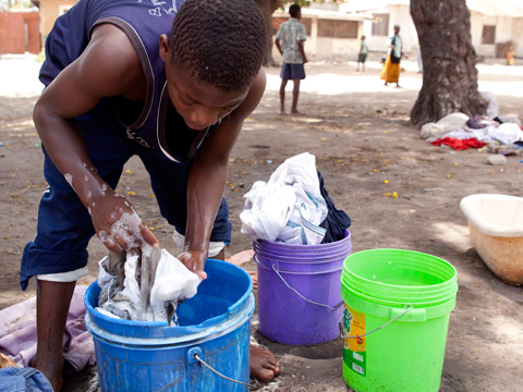 Tansania, Daressalam: Ein junger Mann wäscht seine Wäsche.