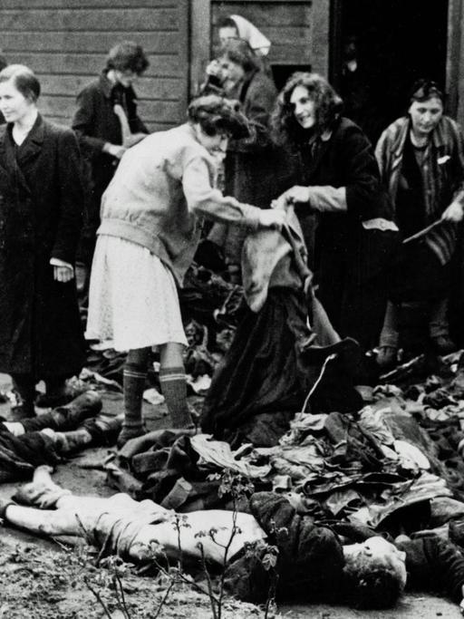 KZ Bergen-Belsen. Befreite Frauen, die sich die Kleidung der Toten holen, nachdem das Lager der Allied 21st Army Group übergeben wurde. Im Lager wurden 55.000 Häftlinge - viele mit Typhus und Ruhr - gefunden. Mehr als 10.000 ehemalige Häftlinge starben nach der Befreiung.